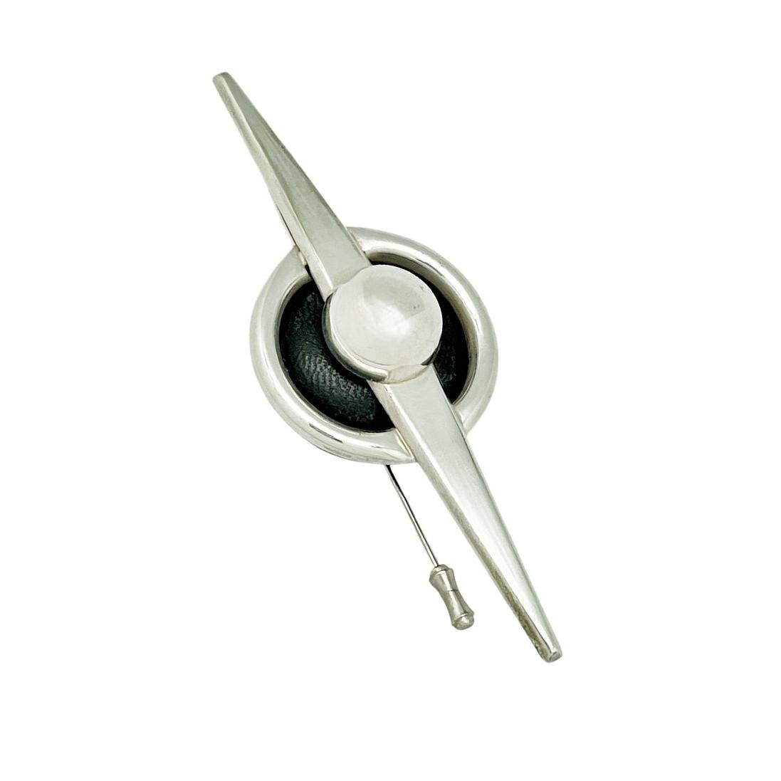 Broche tipo aguja con detalle en piel negra