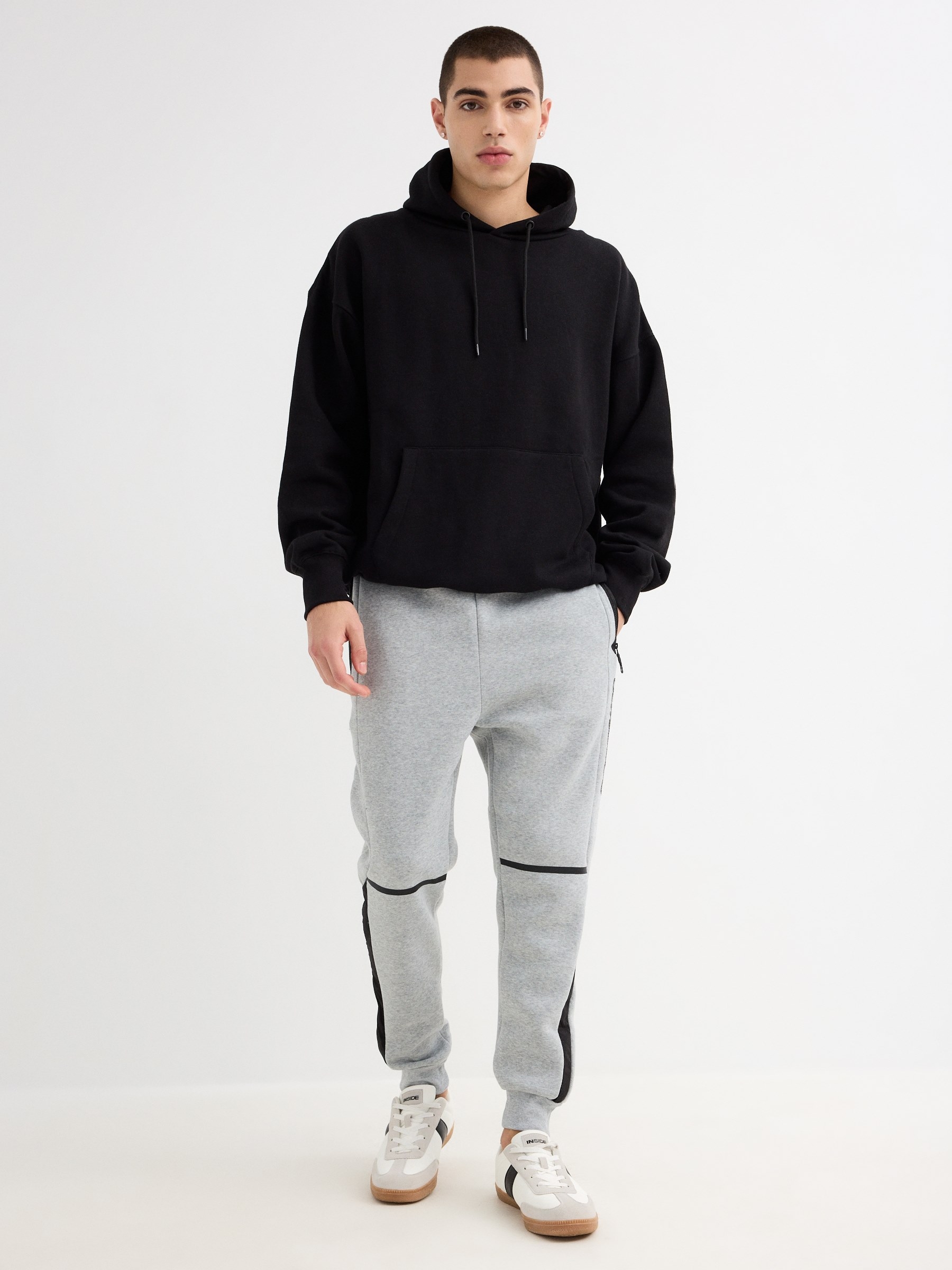 Pantalón jogger deportivo acabado en puño, confeccionado en tejido de felpa, color gris con detalles en negro INSIDE