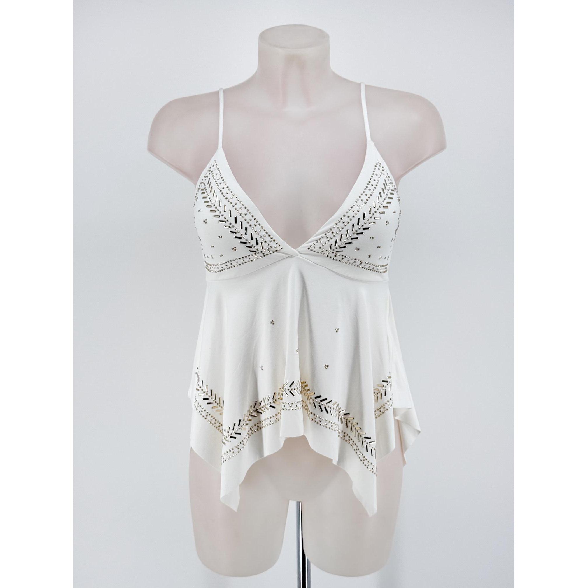 Top de tirantes para mujer con escote en pico pronunciado, tirantes finos regulables, elegante bajo asimétrico en picos y llamativos detalles de tachuelas y apliques metálicos dorados. Disponible en varios colores ideales para un look casual, boho o fiest