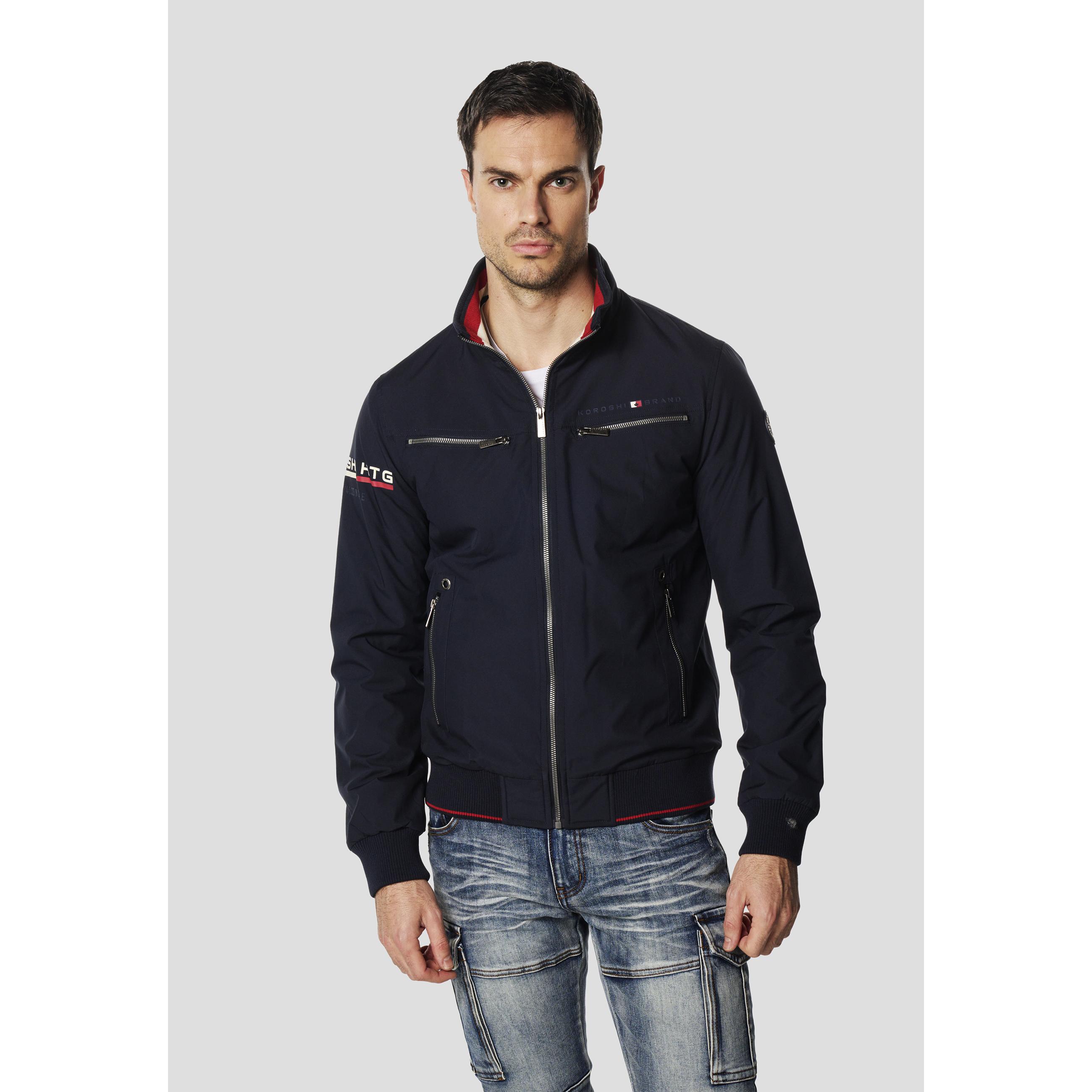 Koroshi - Chaqueta cazadora técnica cortavientos para hombre estilo bomber en azul marino, 100 % poliéster con ribetes rojos y branding náutico KOROSHI