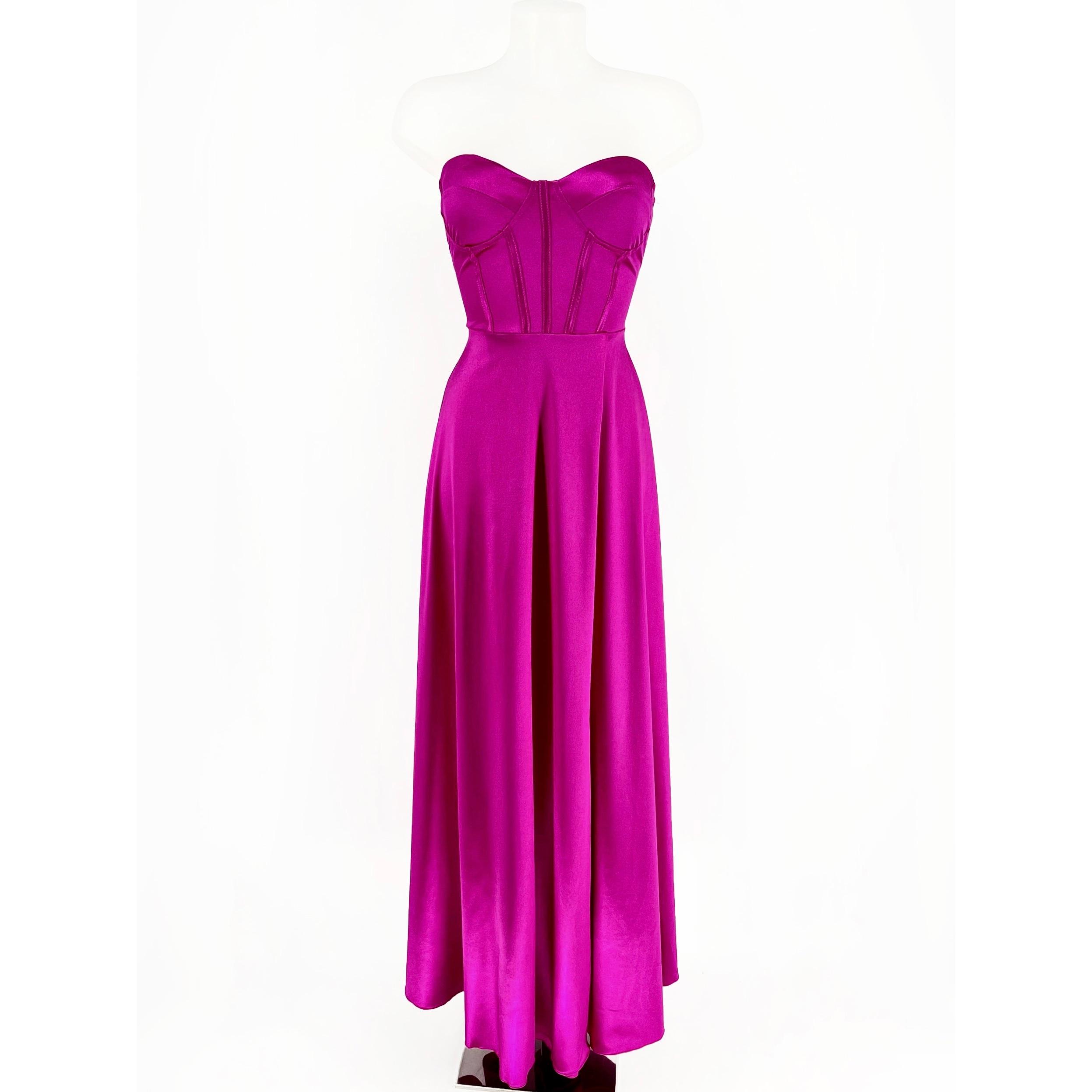 Vestido largo tejido de raso, escote corazón y cuerpo de corsé regulable con lazo en la parte trasera. Tiene copas en el pecho, abertura delantera mostrando la pierna. Amplia falda con vuelo