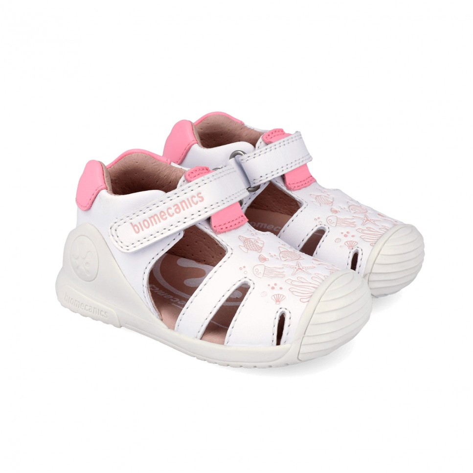 Sandalias respetuosas primeros pasos niña blanco y rosa Biomecanics, blandito y flexible, con puntera protectora y cierre de velcro. Respetuoso con el desarrollo natural del pie. Libre de tóxicos perjudiciales para la salud de pies.