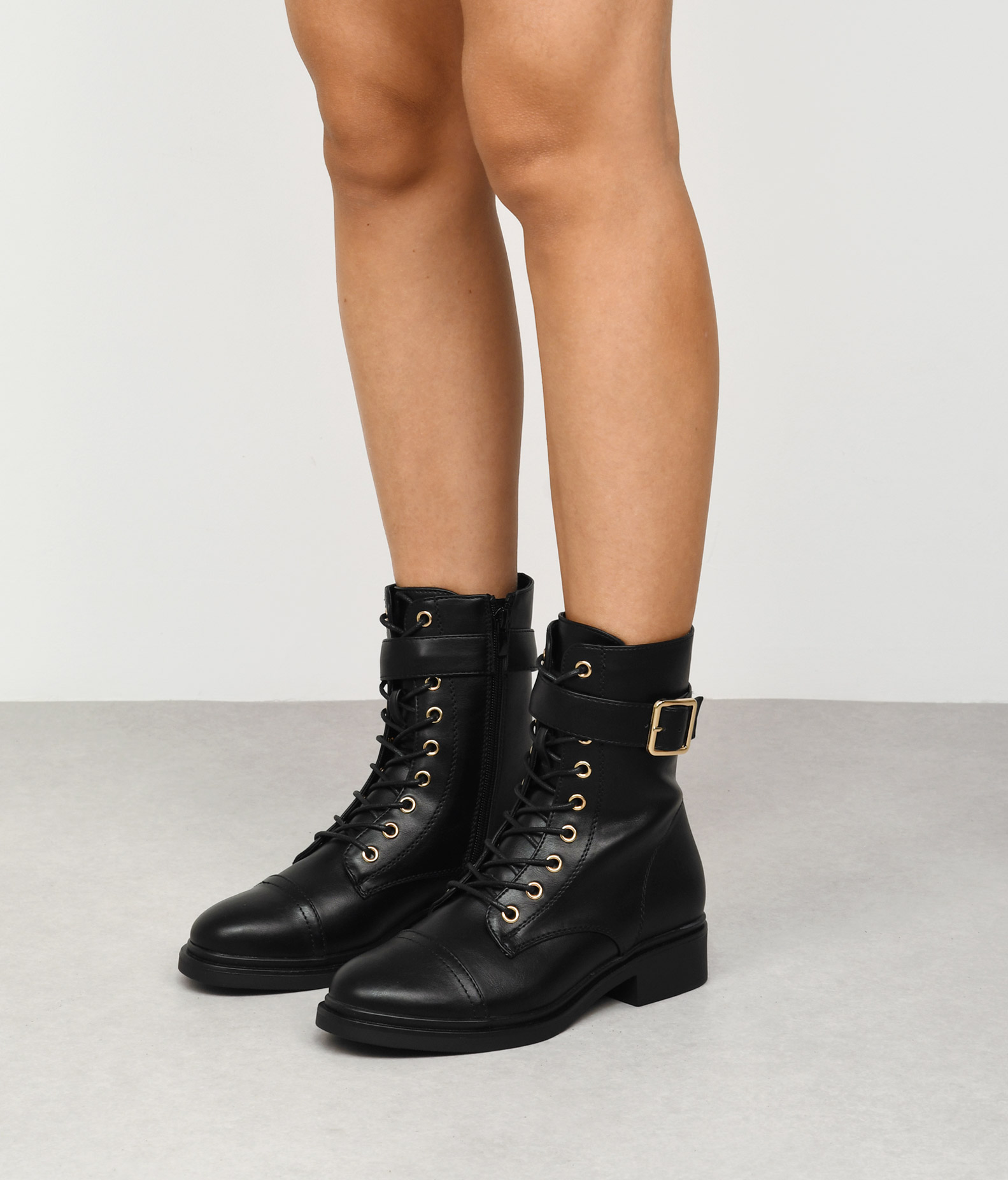 Bosanova Botines planos clásicos para mujer con cordones en vertical, tira decorativa con hebilla y suela plana con tacón de 4 cm. Cierre con cremallera interior.