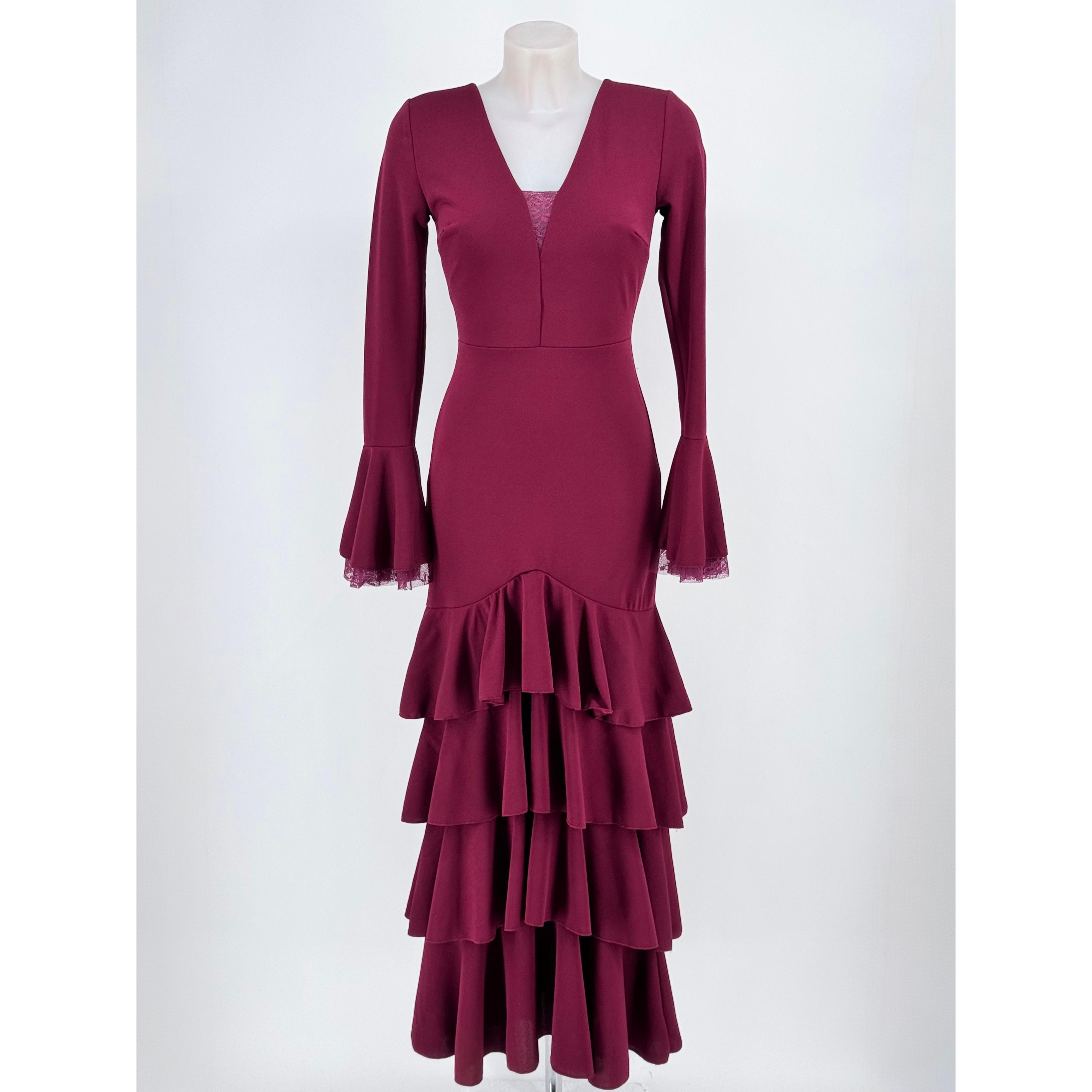 Vestido largo de fiesta en tejido scuba crep con mangas acampanadas y falda de volantes en cascada. Cuello en V con delicado encaje y escote en la espalda. Ajuste perfecto de talla 34 a 40 con cremallera invisible trasera. Ideal para eventos y ferias.