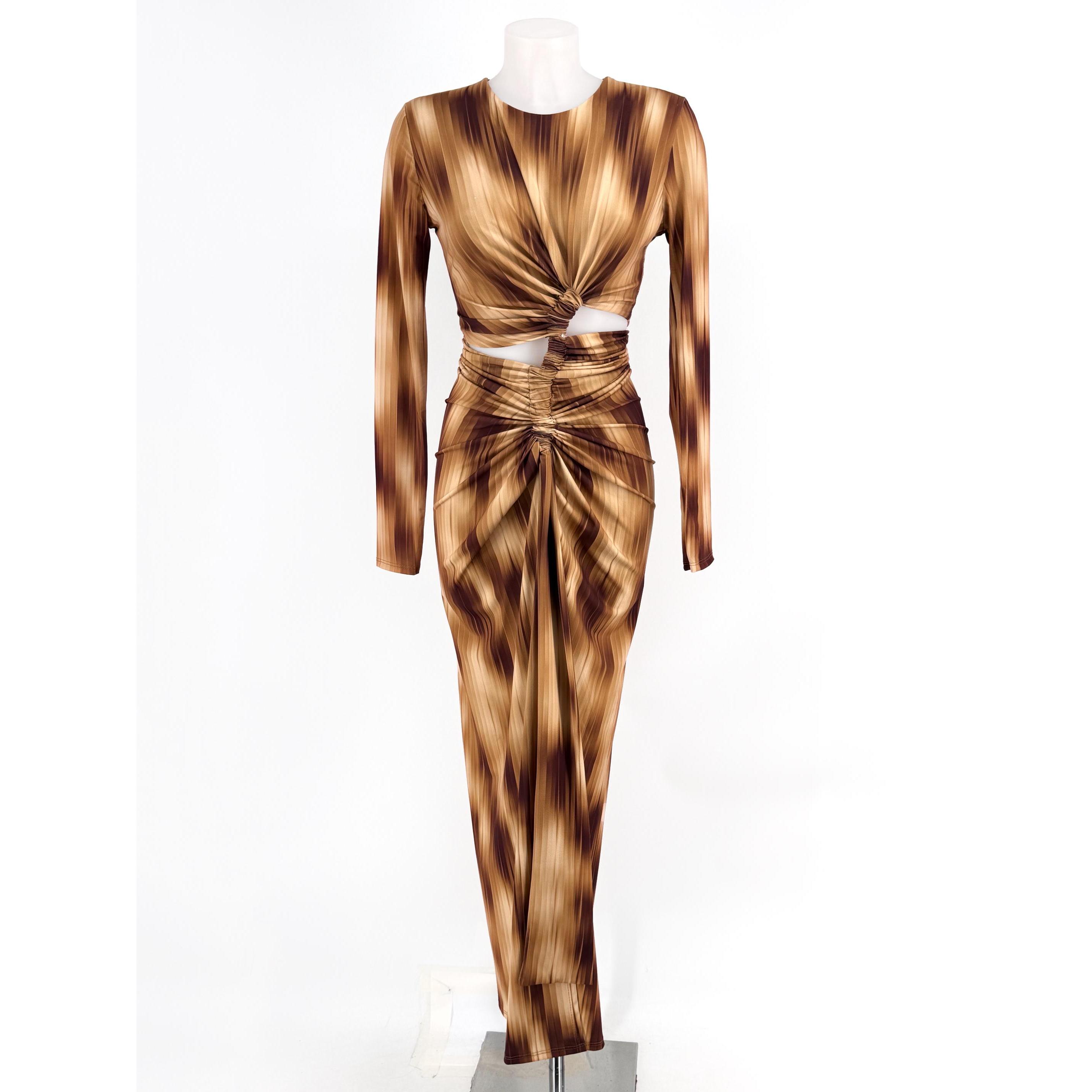 Descubre el vestido largo estampado con nudo y detalle cut-out perfecto para eventos. Diseño de manga larga, escote redondo y falda fruncida con abertura frontal que estiliza la figura. Talla única adaptable de la 34 a la 40. ¡Disponible en varios tonos!