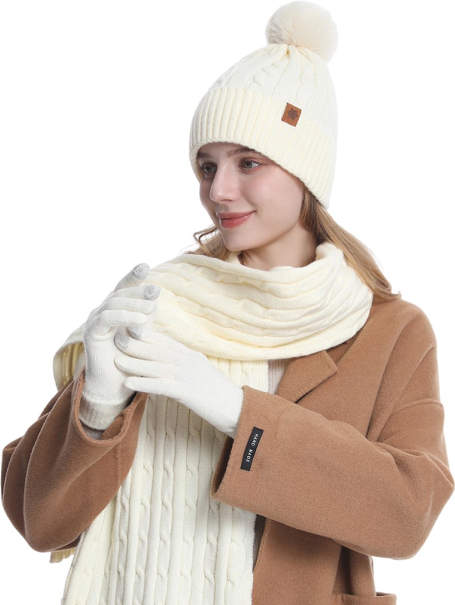 Winterset bestaande uit drie items: een muts, sjaal, handschoenen en een gebreide muts met pompons, geschikt voor dagelijks gebruik en buitenactiviteiten in de herfst en winter. Wit.